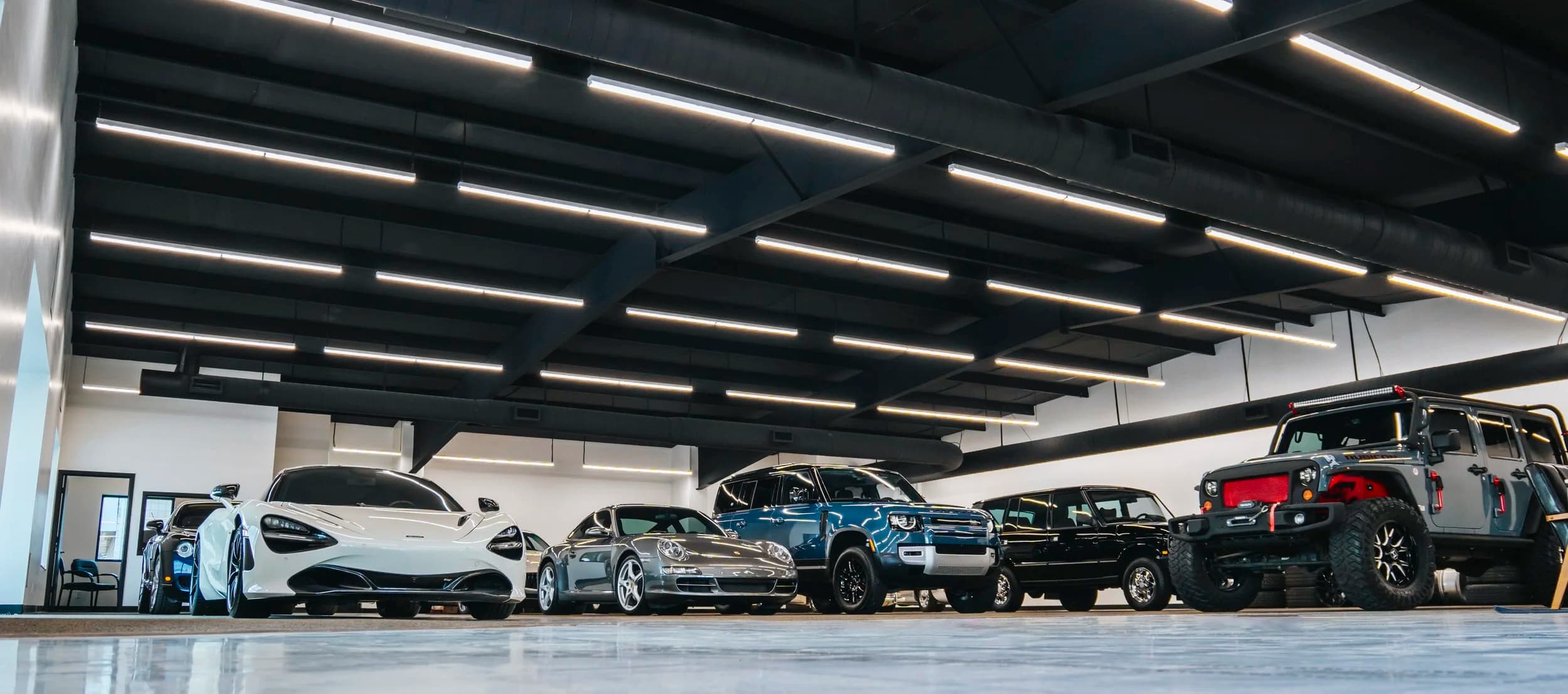 Modern Dubai automotive showroom floor with premium vehicles on display